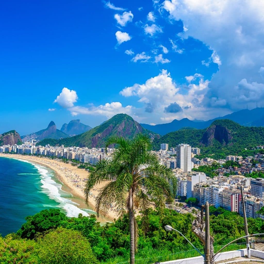 Copacabana beach in Rio de Janeiro, Brazil. Copacabana beach is the most famous beach of Rio de Janeiro, Brazil. Skyline of Rio de Janeiro with flag of Brazil